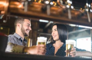 Young couple enjoying beer at a pub, fun things to do in Duluth 